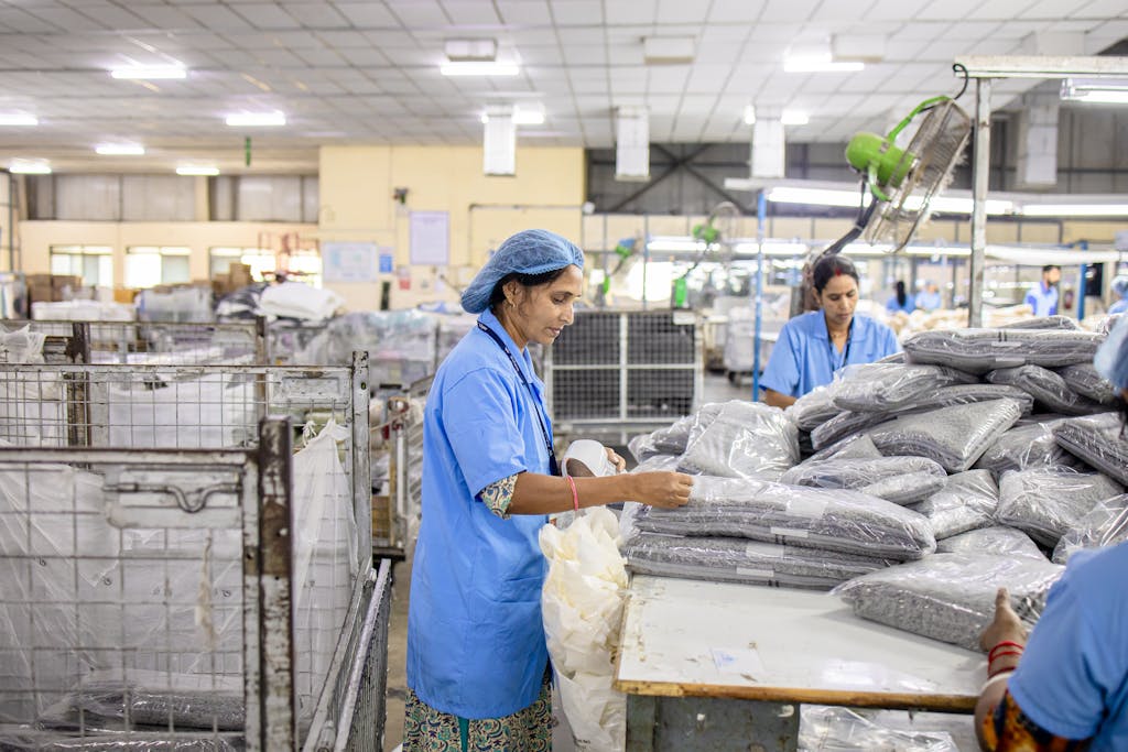 Blue-Collar Factory Workers on the Job | Industrial Workforce Photo. Group of blue-collar factory workers operating machinery in an industrial manufacturing facility.