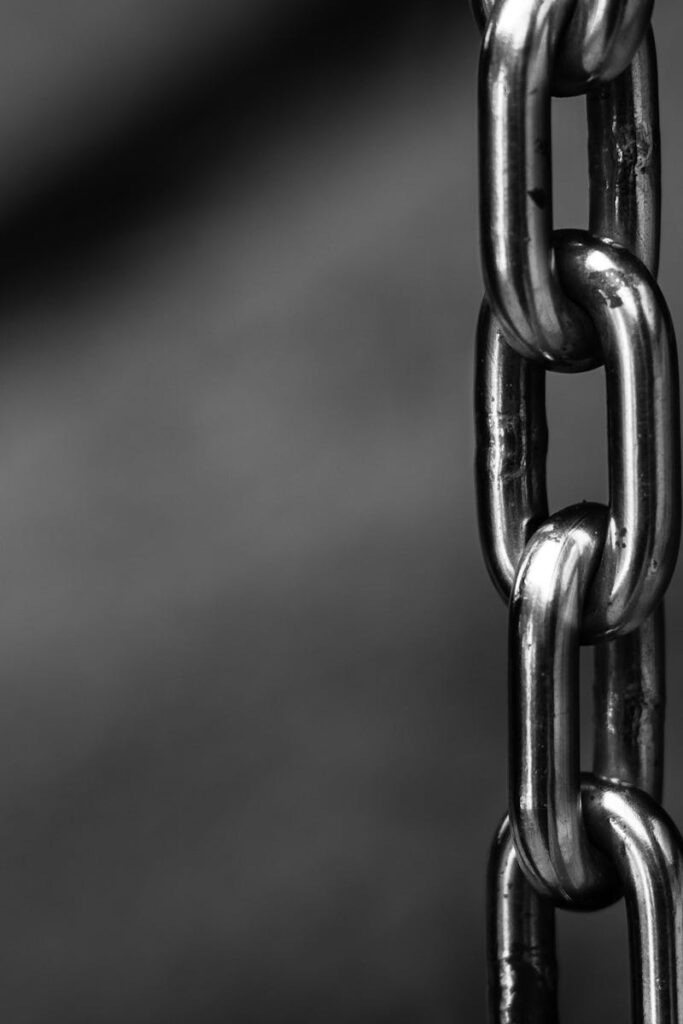 Secure Data Protection: The Foundation of Professional CRM Systems. Detailed close-up of a strong shiny metallic chain link against a blurred background, emphasizing security.